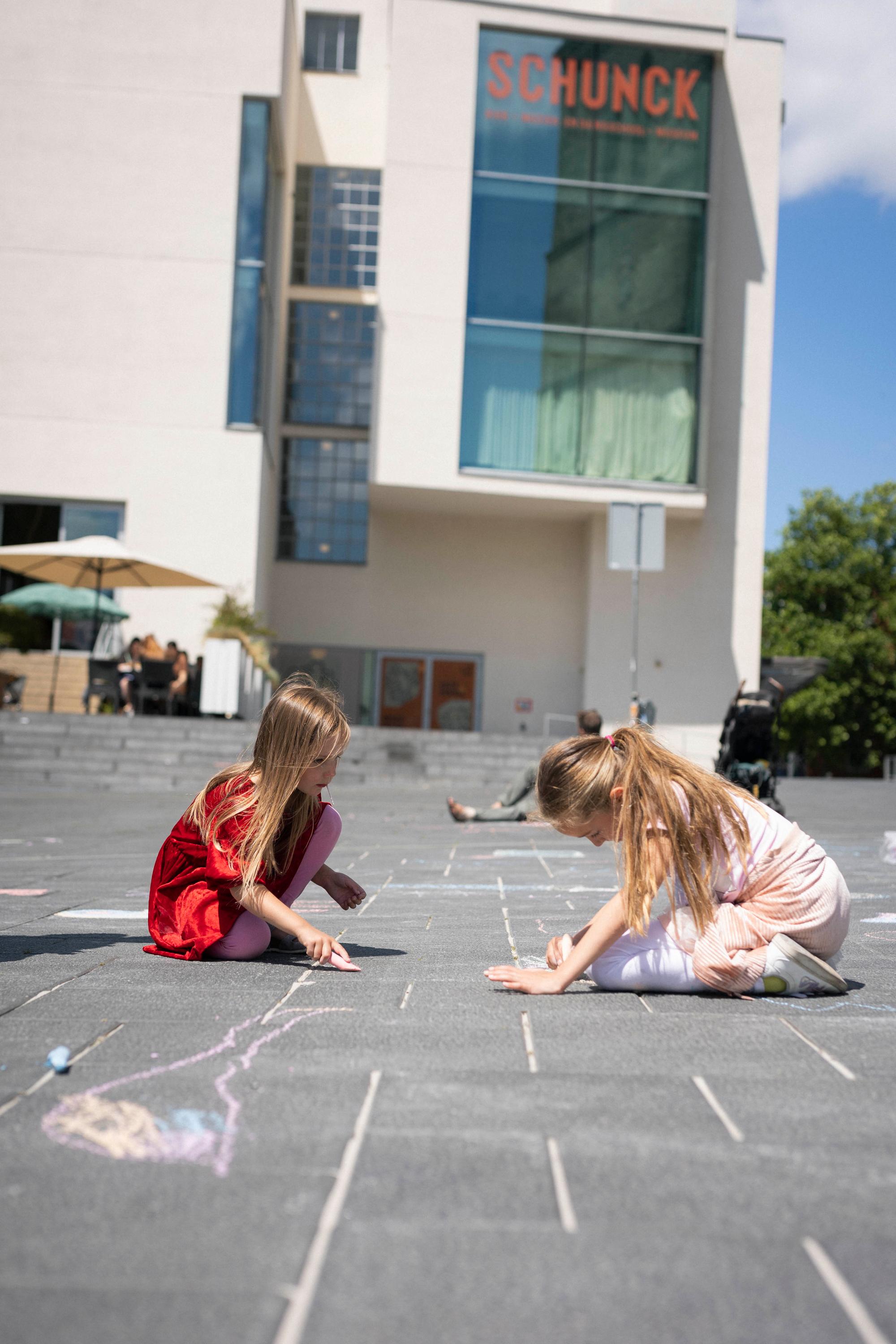 Twee kinderen krijten op het Pancratiusplein voor SCHUNCK Glaspaleis. 