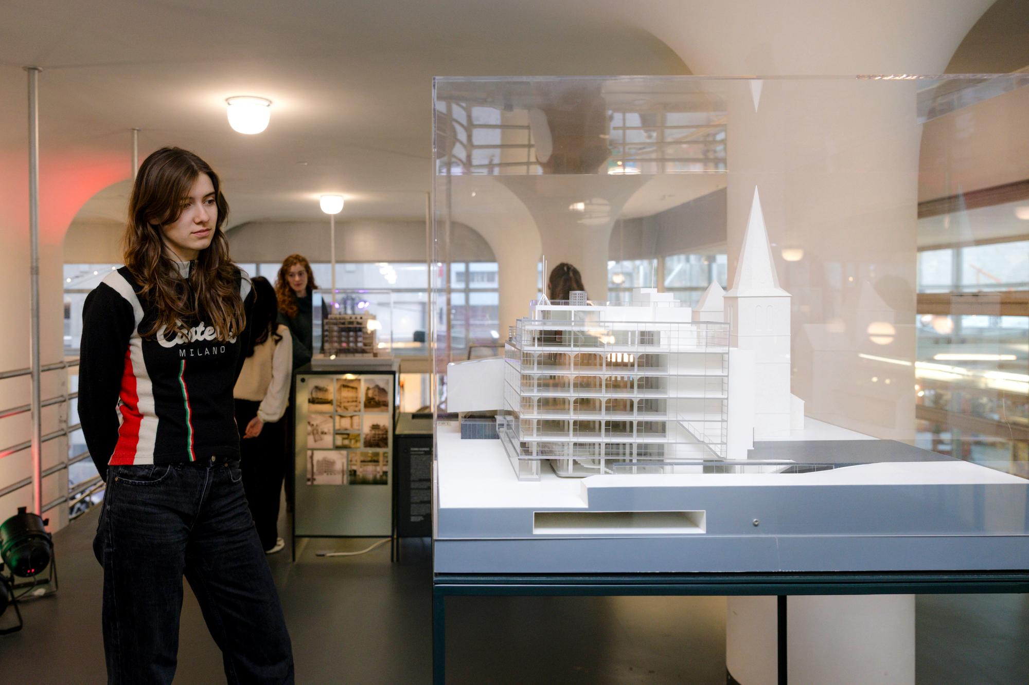 Bezoeker bekijkt een architectuurmaquette van het Glaspaleis in een tentoonstelling over de geschiedenis en ontwikkeling van het gebouw.